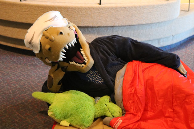 Dinosaur wearing sleep mask enjoys Night in the Museum, a fun indoor activity for families.