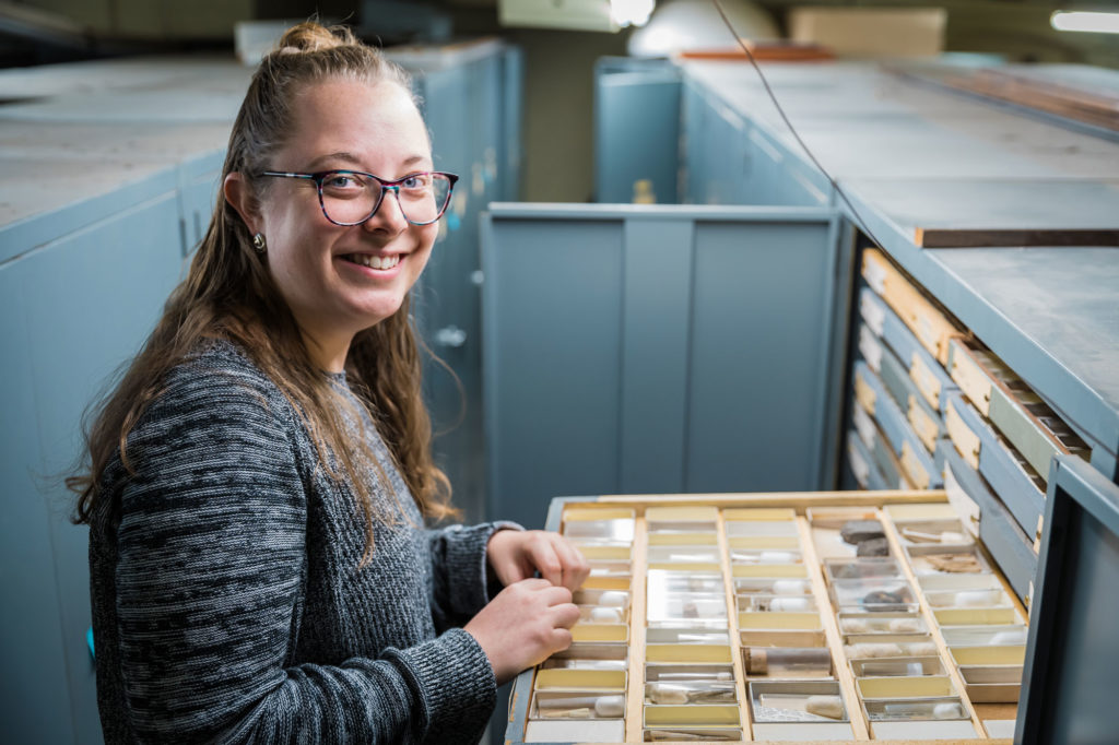 Female scientist with open drawer of invert paleo fossils