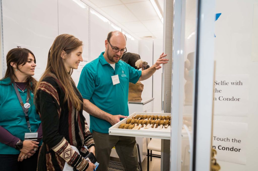 Ornithologist shows bird specimens to adults