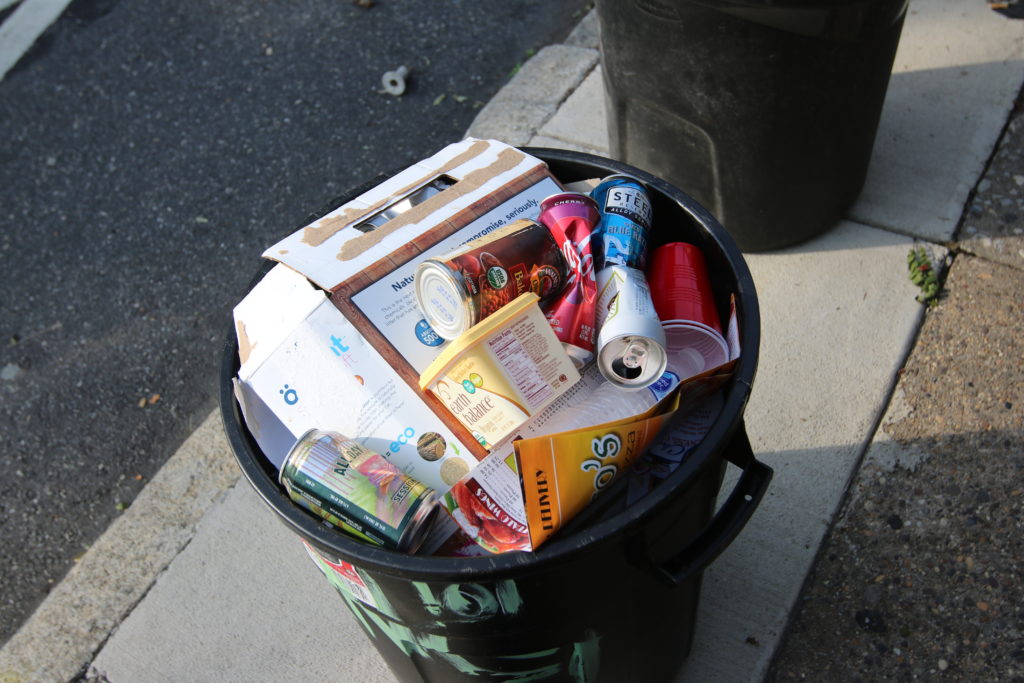 Full recycling bucket on sidewalk