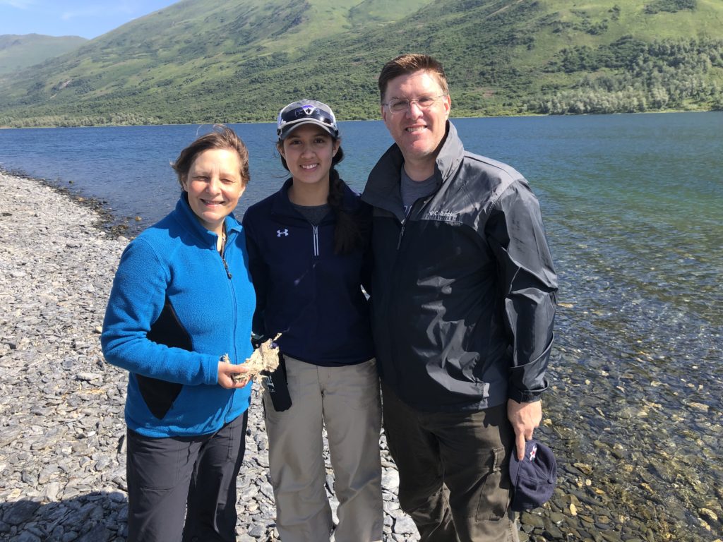 Three scientists stand beside Karluk Lake on Kodiak Island, Alaska