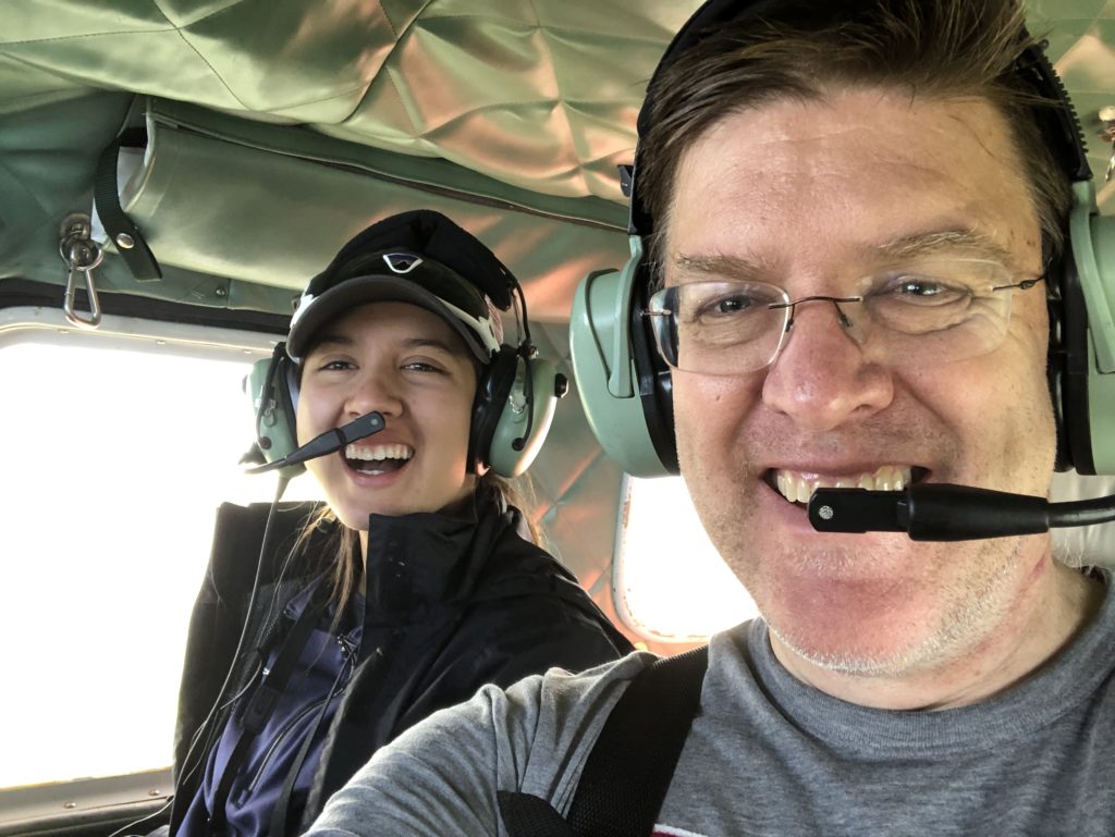 Two scientists ride in plane with earmuffs and mouth pieces