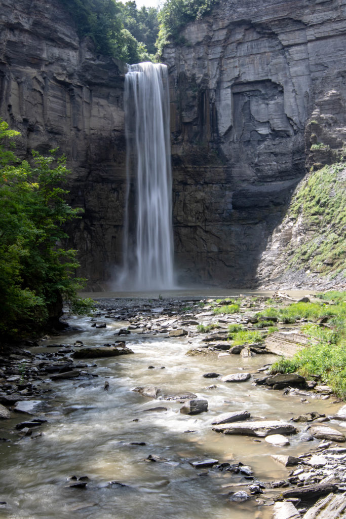 large waterfall in front of gray rocks