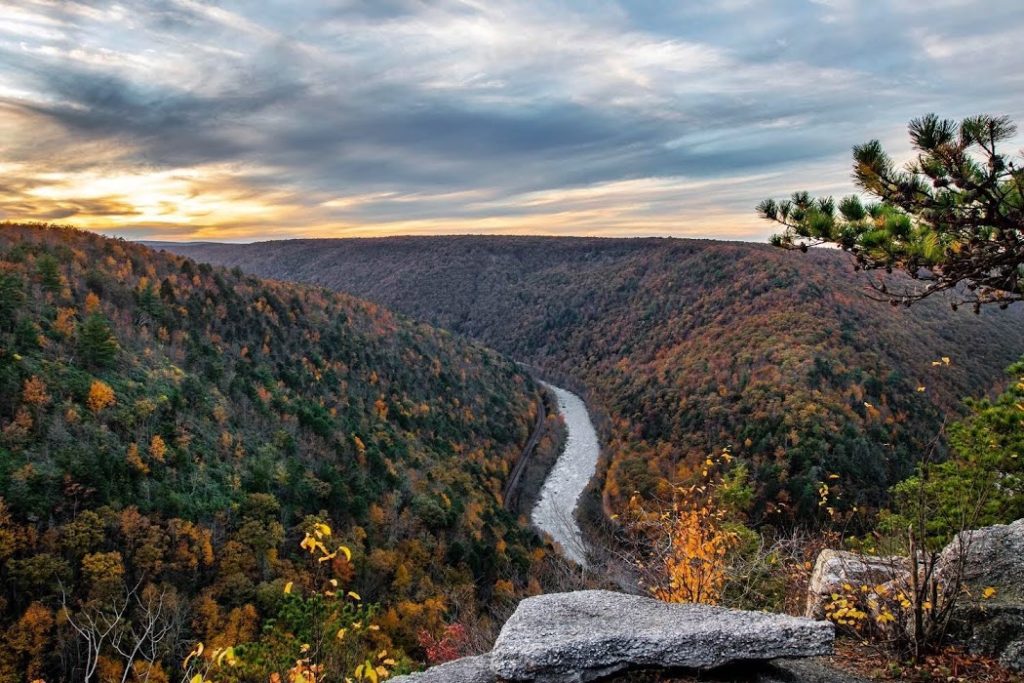 vista looking over river with red and orange fall foliage