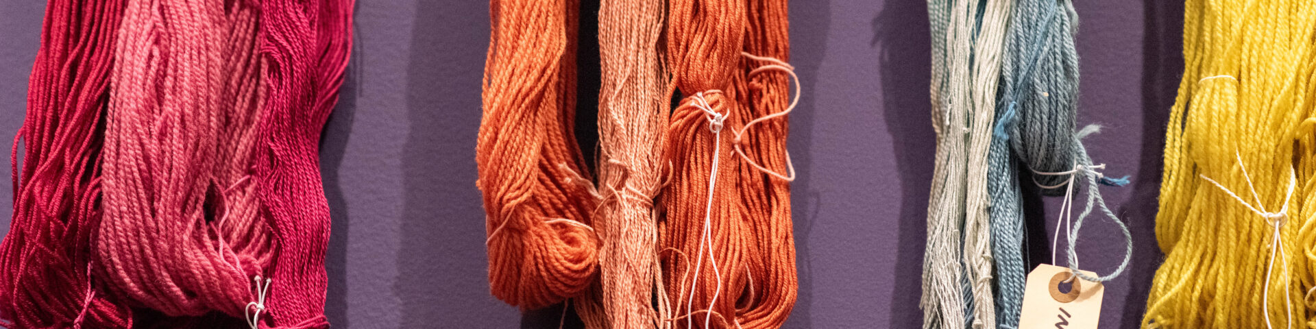 colored yarn hanging on wall